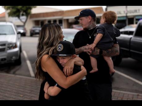 Mikayla Brown (left) comforts her son, Jax, as they stand in front of a park bench dedicated to her son, Elijah Ott, who died of a fentanyl overdose at 15, in Paso Robles, California.