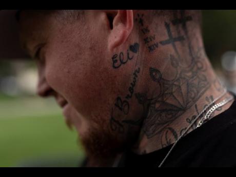 With his stepson’s name tattooed below his ear, Tyler Brown, stepfather of Elijah Ott, who died of a fentanyl overdose at 15, looks at a park bench dedicated to Elijah in Paso Robles, California.