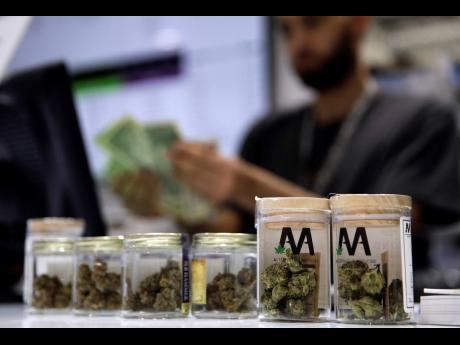 A cashier rings up a marijuana sale, July 1, 2017, at a cannabis dispensary in Las Vegas.