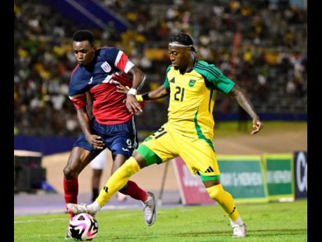 
Reggae Boy winger Norman Campbell tries to get between Cuba’s Maikel Reyes and the ball during a Concacaf Nations League, League A, Group B game inside the National Stadium on September 6.