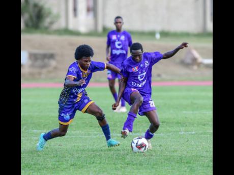 
Cumberland’s Robert Walcott (left) battles for possession with Kingston College’s Dasawn Blackwood during their ISSA/WATA Manning Cup match at Stadium East Yesterday.