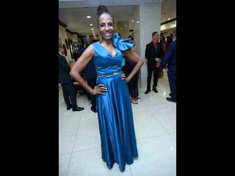 Jacqueline Donaldson, vice president of group corporate services, Sagicor, dons a blue gown with statement earrings and a fun fabric flower detail. 