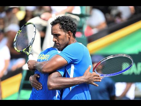 
Barbadians Haydn Lewis (right) and Darian King  embrace  after defeating Jamaica in a Davis Cup doubles match earlier this year at the Eric Bell Tennis Centre.