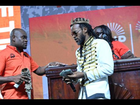 Entertainer LA Lewis (right) makes what he said was a more than $2-million donation to the PNP during the party’s annual conference. 