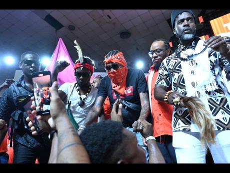 Vybz Kartel (centre) and Accompong Maroon Chief Richard Currie (right) at the People’s National Party 86th annual conference at the National Arena in Kingston yesterday.