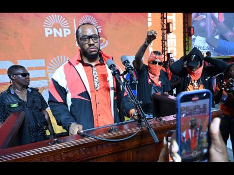 Attorney Isat Buchanan and his client, controversial entertainer Vybz Kartel, on stage at the PNP’s annual conference. 