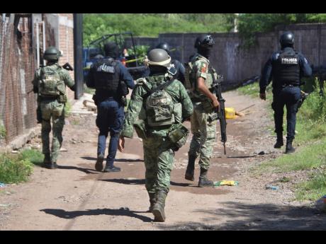 Soldiers and police arrive at the area where bodies lie on the ground in Culiacan, Sinaloa state, Mexico, on Tuesday.