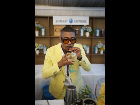 Rushane ‘RushCam’ Campbell, Caribbean Producers Jamaica’s official brand ambassador for the 10th anniversary of the Jamaica Food and Drink Festival, takes a sip of his gin cocktail dressed to the nines in a yellow suit. 