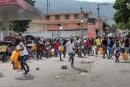 People run for cover as police shoot into the air to disperse a crowd threatening to burn down a gas station because they believed the station was withholding the gas, in Port-au-Prince, Haiti, last October.