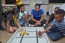 
At the Junior Creator Robotic Camp, Supreme Ventures Limited (SVL) Social and Digital Media Asst. Manager, Precianne Miller (middle), sits in with the excited students of Independence Primary School (from left to right): Katalina Baroo, Javaughn Dixon, an