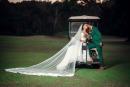 The beautiful couple share a kiss on the golf course. 