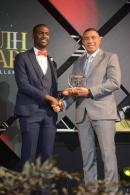 Evad Campbell (left), receives the 2023 Prime Minister National Youth Award for Excellence in music from Prime Minister Andrew Holness. 