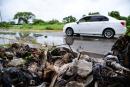 A car drives past a pile of garbage on the side of Pacific Boulevard in Seaview Gardens, St Andrew.